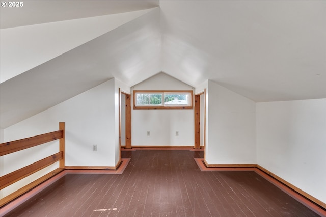 bonus room featuring dark wood-type flooring and vaulted ceiling