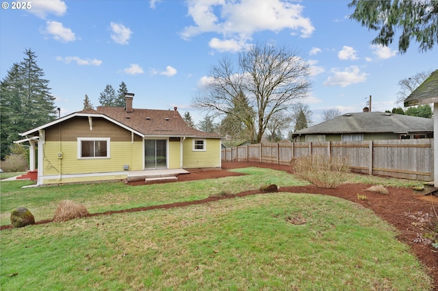 rear view of property featuring a lawn