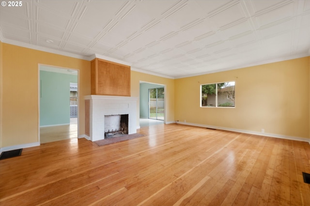 unfurnished living room featuring hardwood / wood-style floors and a brick fireplace