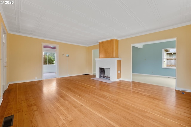 unfurnished living room with light hardwood / wood-style floors and crown molding