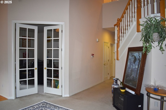 interior space featuring carpet flooring, french doors, stairway, and baseboards