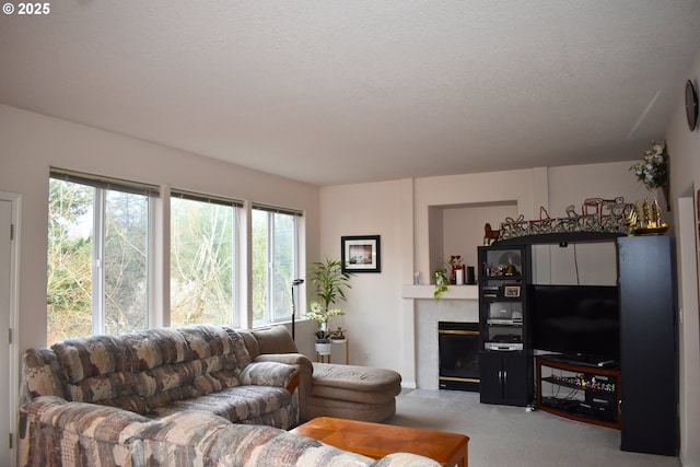 carpeted living area with a tiled fireplace and a textured ceiling