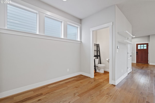 empty room featuring light wood finished floors and baseboards