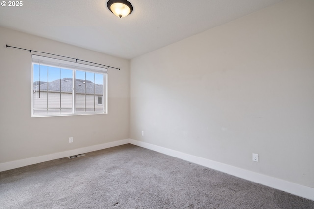 unfurnished room featuring carpet and baseboards