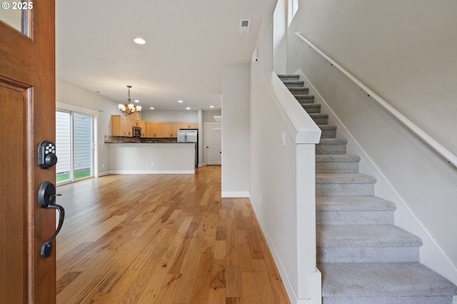 foyer with a chandelier, recessed lighting, stairway, light wood-style floors, and baseboards