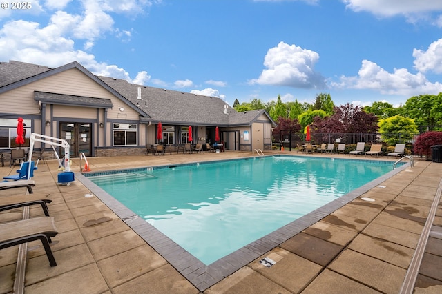 community pool featuring a patio, french doors, and fence