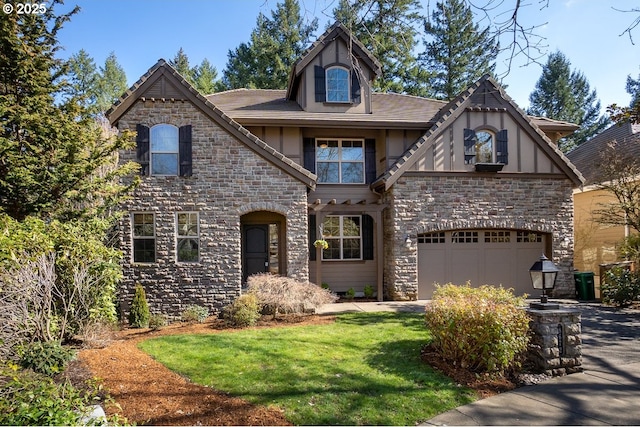 view of front of home with stucco siding, driveway, stone siding, a front yard, and a garage