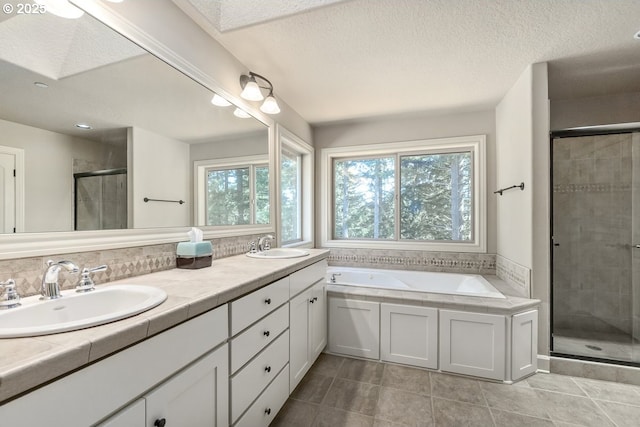 bathroom featuring a sink, a stall shower, double vanity, and a bath