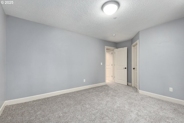 empty room with baseboards, carpet floors, and a textured ceiling