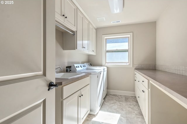 clothes washing area featuring baseboards, visible vents, cabinet space, a sink, and independent washer and dryer