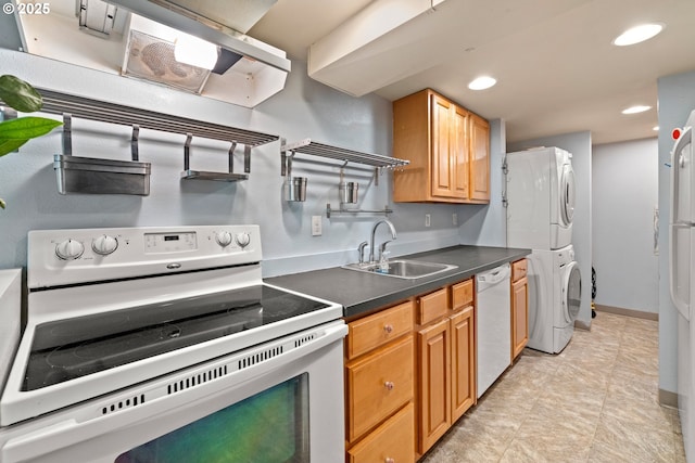 7750 SW 4th Ave, Portland, OR 97219 - kitchen with white appliances, stacked washing machine and dryer, a sink, dark countertops, and recessed lighting