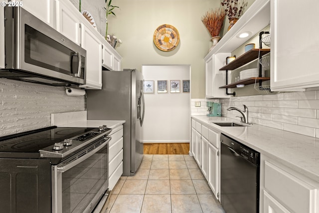 7750 SW 4th Ave, Portland, OR 97219 - kitchen featuring stainless steel appliances, a sink, open shelves, white cabinets, and decorative backsplash