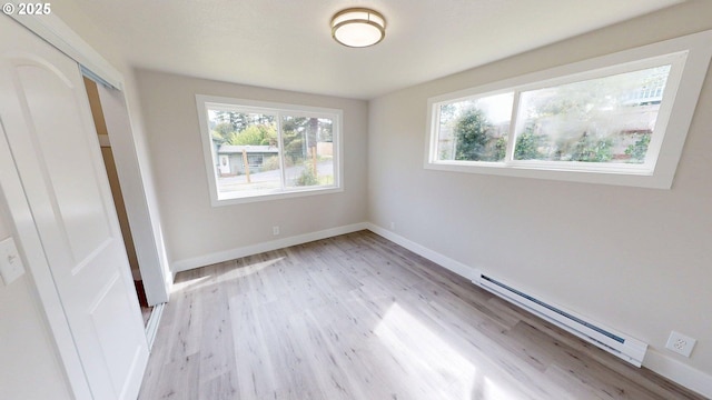 29700 Park Dr, Gold Beach, OR 97444 - unfurnished bedroom with multiple windows, a baseboard heating unit, and light wood-type flooring