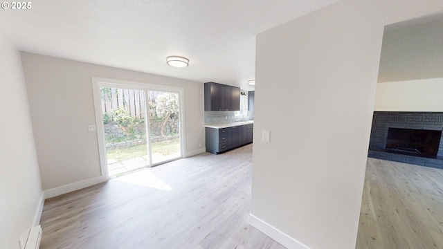 29700 Park Dr, Gold Beach, OR 97444 - unfurnished living room featuring light wood-style flooring, baseboards, and a fireplace