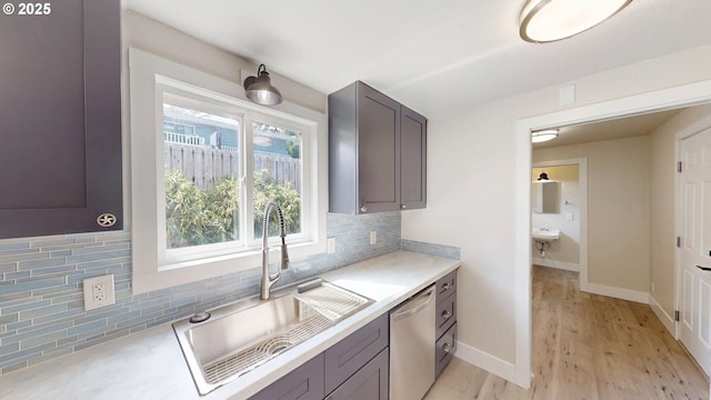 29700 Park Dr, Gold Beach, OR 97444 - kitchen with a sink, dishwasher, light countertops, light wood finished floors, and backsplash