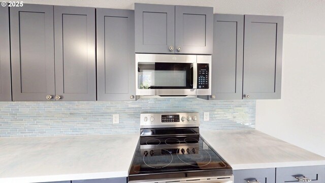 29700 Park Dr, Gold Beach, OR 97444 - kitchen featuring appliances with stainless steel finishes, gray cabinets, light countertops, and backsplash