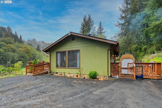 view of home's exterior featuring an outbuilding and a wooden deck