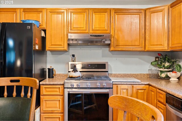 kitchen with light countertops, under cabinet range hood, and stainless steel appliances