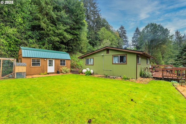 exterior space with an outdoor structure, a front lawn, exterior structure, and a wooden deck