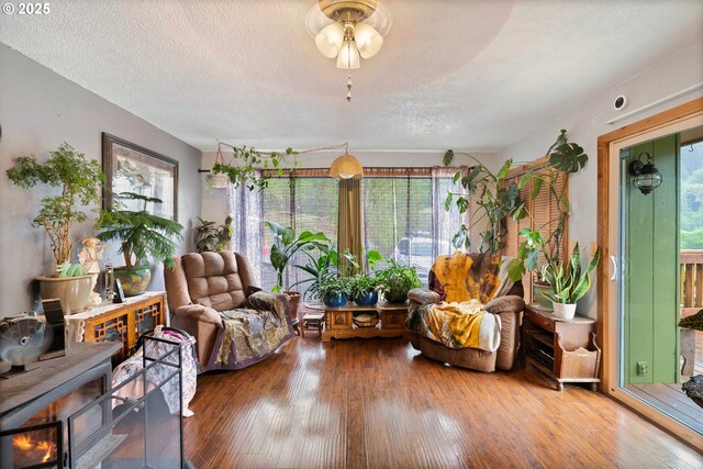 living area with a textured ceiling and hardwood / wood-style flooring