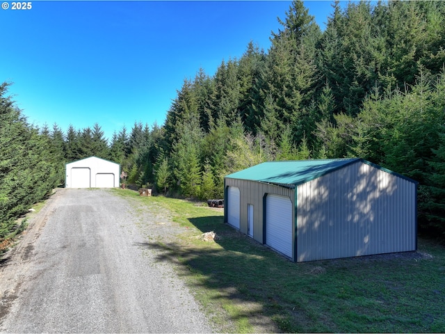 detached garage with a view of trees