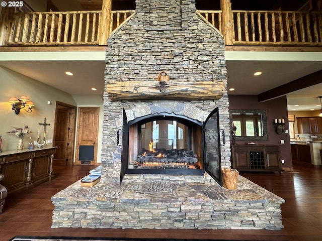 interior details featuring recessed lighting, a stone fireplace, and wood finished floors