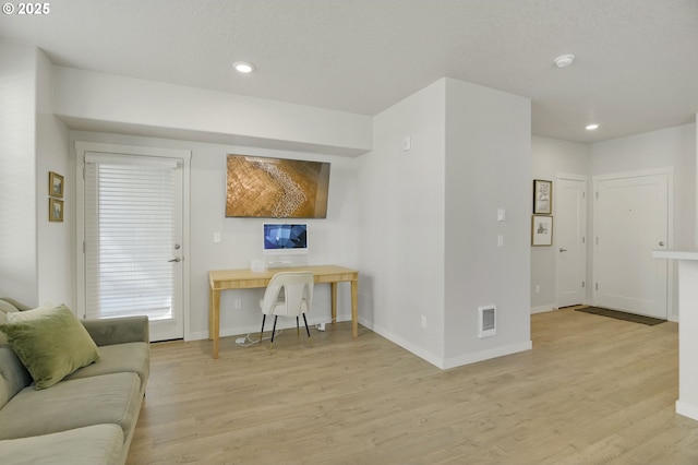 living area with light wood-style floors, baseboards, visible vents, and recessed lighting