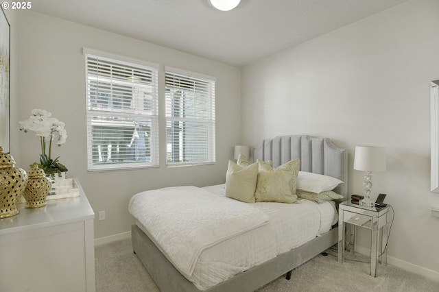 bedroom featuring baseboards and light colored carpet