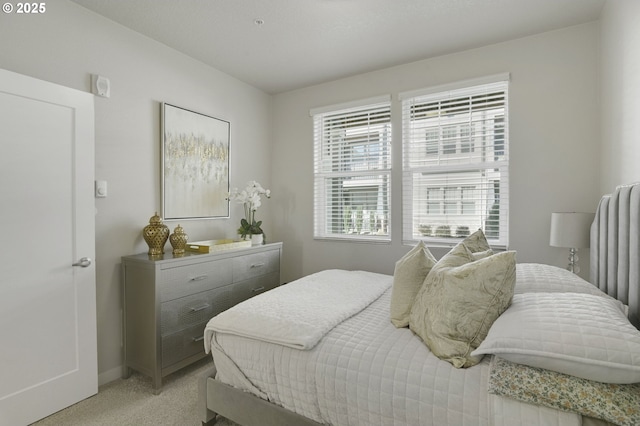 bedroom featuring light colored carpet and baseboards