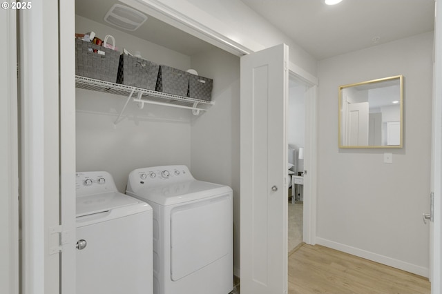 laundry room featuring laundry area, baseboards, visible vents, wood finished floors, and independent washer and dryer