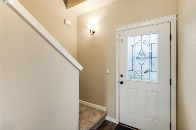 foyer entrance featuring baseboards and stairs