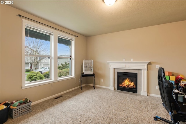 carpeted office space with visible vents, a fireplace, baseboards, and a textured ceiling