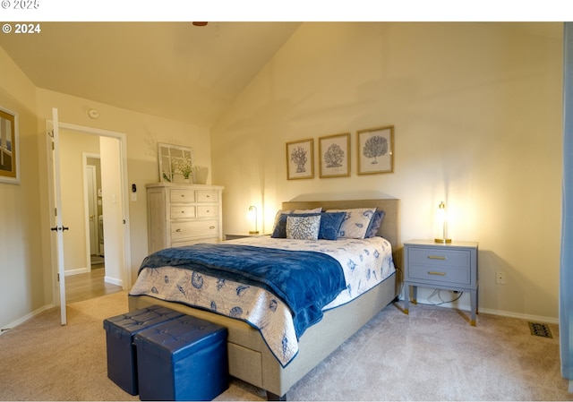 carpeted bedroom with high vaulted ceiling