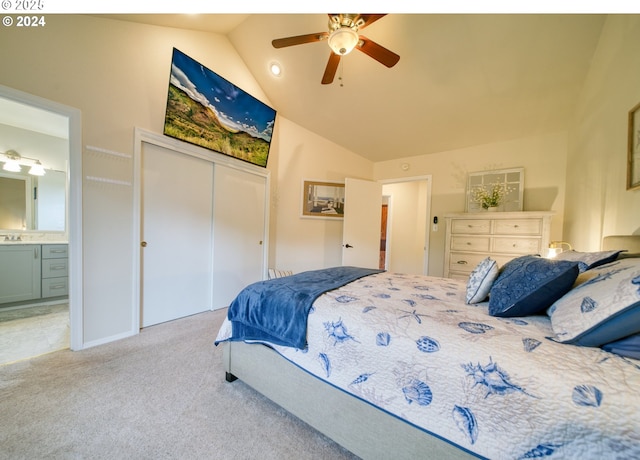 bedroom with ensuite bathroom, ceiling fan, a closet, light colored carpet, and vaulted ceiling