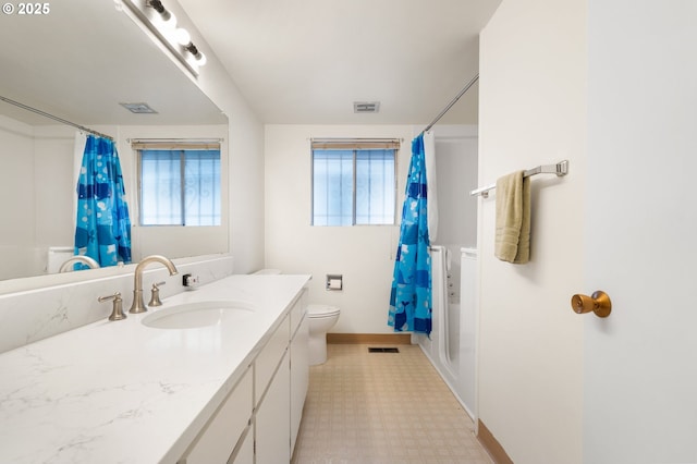 full bath featuring toilet, visible vents, vanity, baseboards, and tile patterned floors