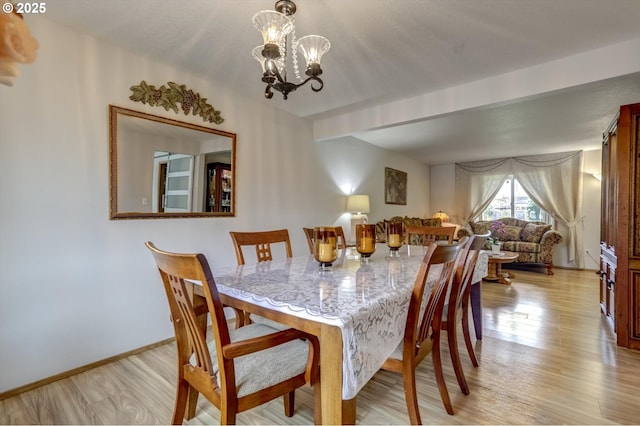 dining room featuring a chandelier, light wood-style flooring, baseboards, and beamed ceiling
