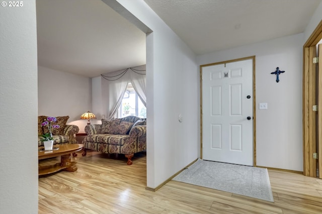 entryway with baseboards and light wood finished floors