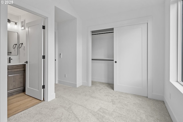 carpeted bedroom with a closet and ensuite bathroom