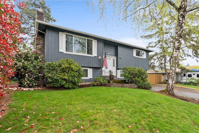 bi-level home with a chimney and a front yard