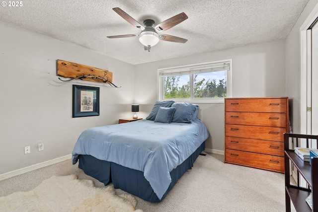carpeted bedroom featuring baseboards, a ceiling fan, and a textured ceiling