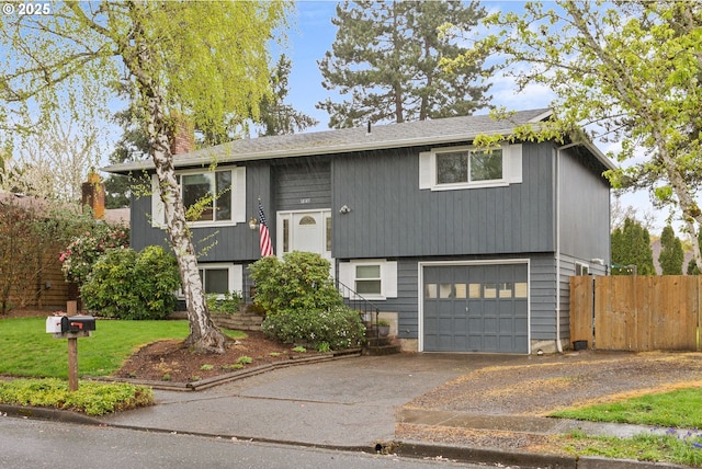 bi-level home with a chimney, driveway, a garage, fence, and a shingled roof
