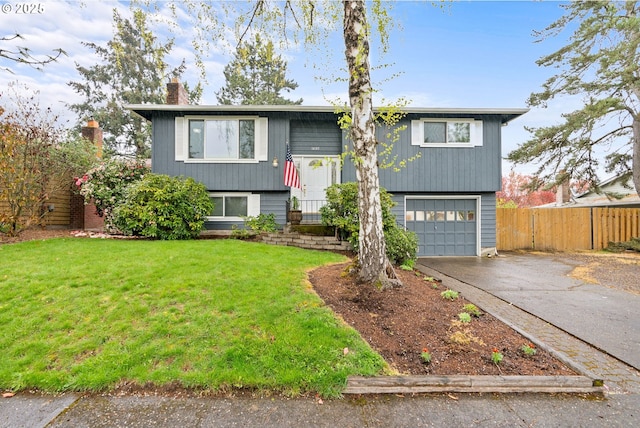 split foyer home with a garage, a chimney, aphalt driveway, fence, and a front lawn
