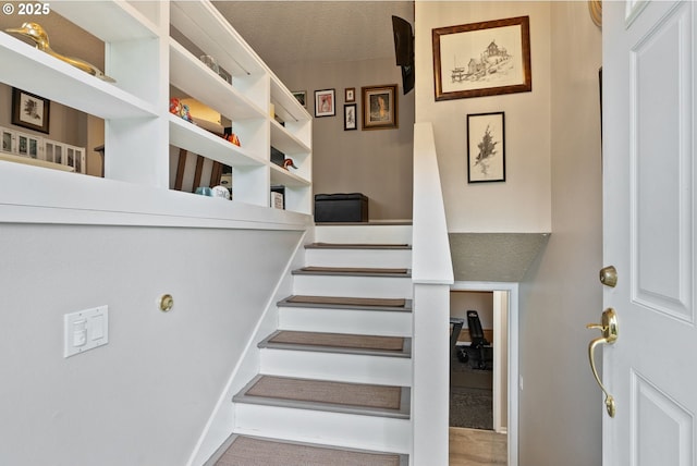 stairs featuring a textured ceiling
