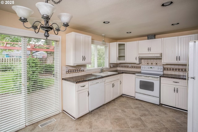 821 13th Ave, Seaside, OR 97138 - kitchen featuring white appliances, a chandelier, under cabinet range hood, dark countertops, and decorative backsplash