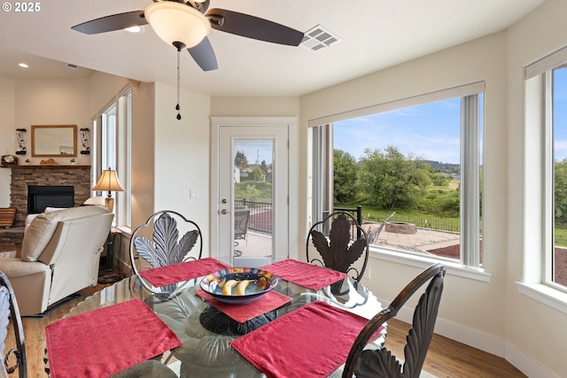 910 Swallow Ave, Sutherlin, OR 97479 - dining room with wood finished floors, healthy amount of natural light, a fireplace, and ceiling fan