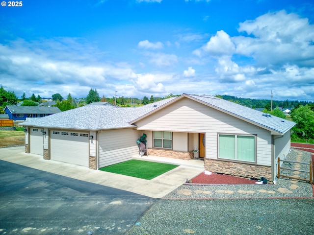 910 Swallow Ave, Sutherlin, OR 97479 - ranch-style home featuring stone siding, a garage, driveway, and a shingled roof