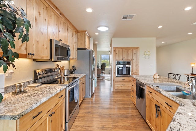 910 Swallow Ave, Sutherlin, OR 97479 - kitchen with stainless steel appliances, light brown cabinetry, light wood-style floors, recessed lighting, and a sink