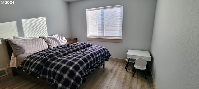 bedroom featuring baseboards and wood finished floors