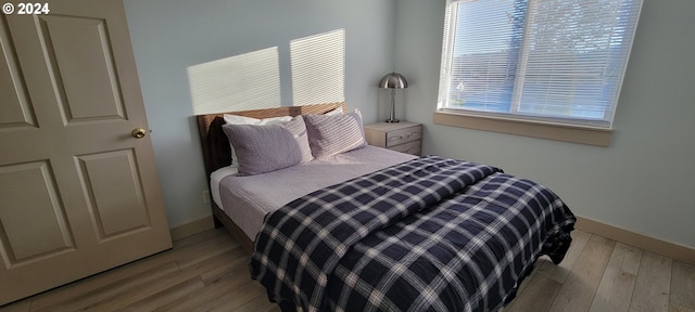 bedroom featuring baseboards and wood finished floors