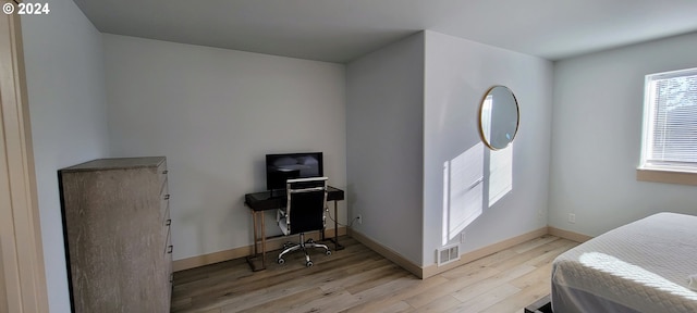 bedroom with baseboards, wood finished floors, and visible vents